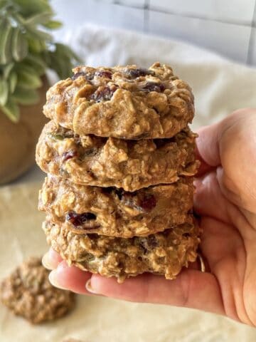 human hand holding a stack of breakfast cookies.
