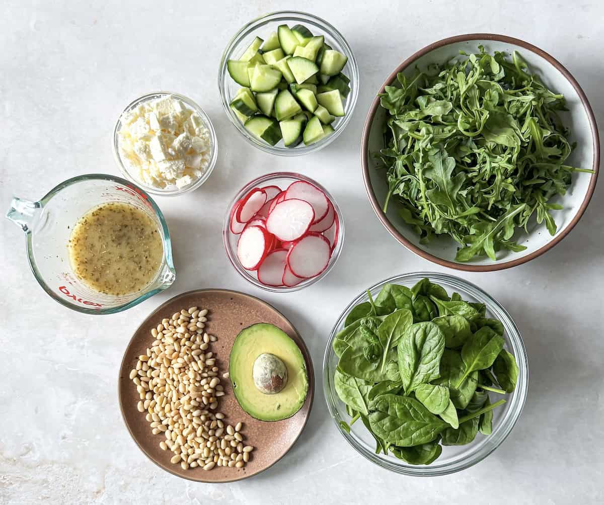 ingredients for arugula and spinach salad on a table.