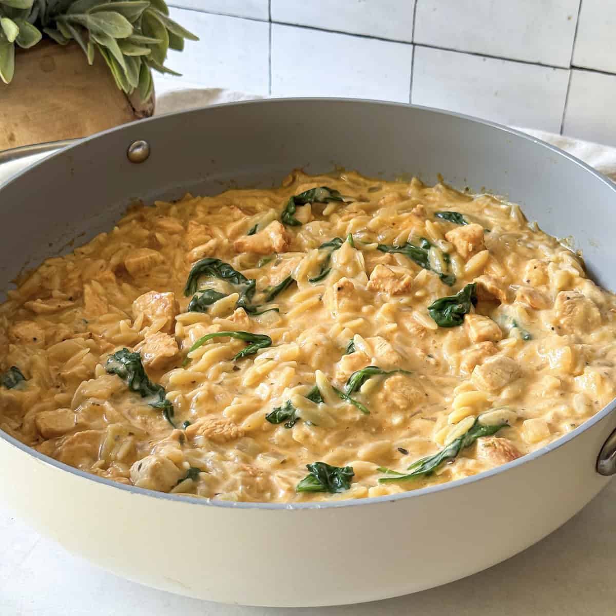 side view of lemon chicken orzo in a skillet.