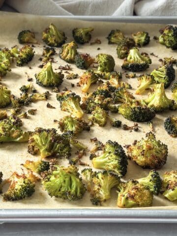 roasted broccoli on a sheet pan side view.