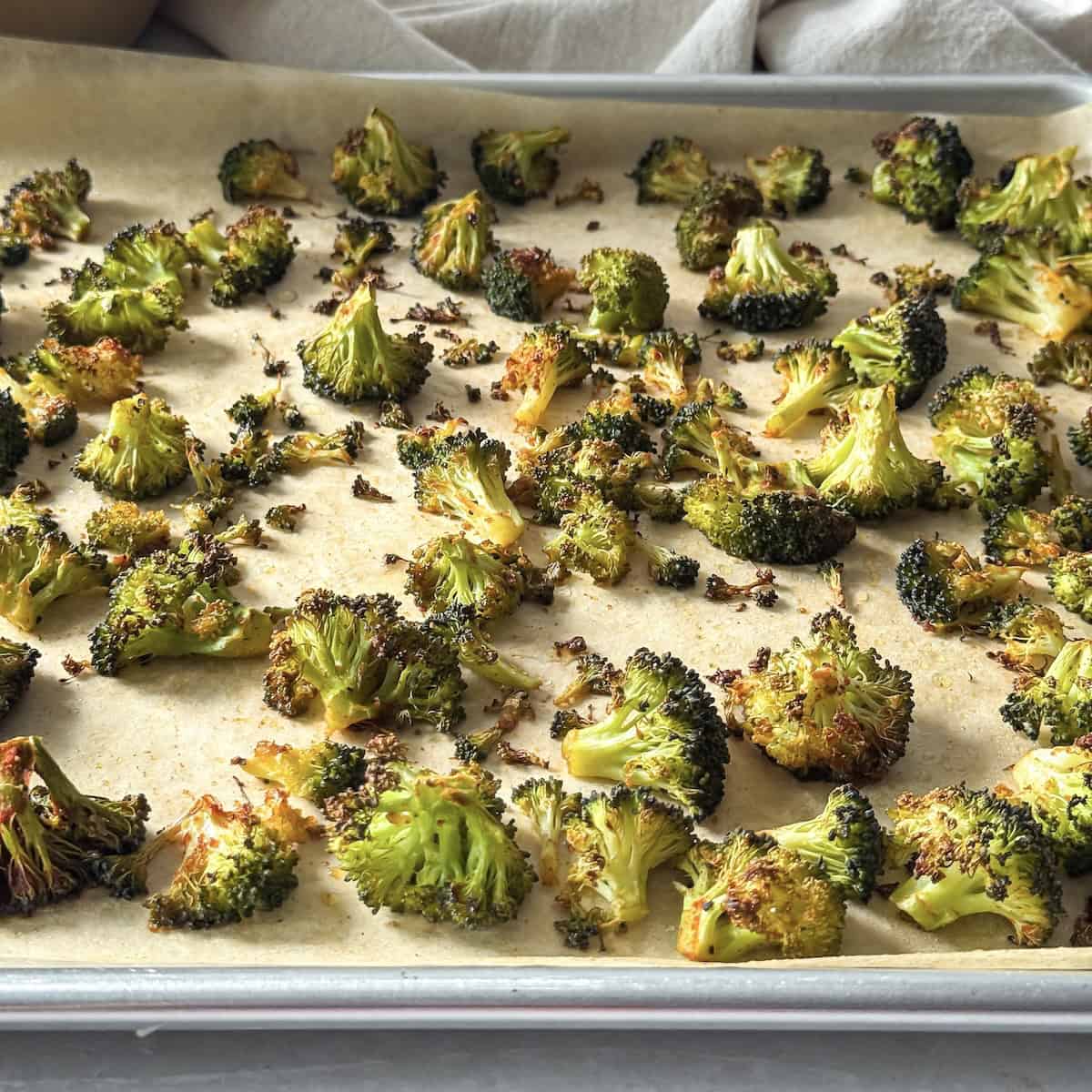 roasted broccoli on a sheet pan side view.