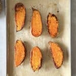roasted sweet potato halves on a baking sheet overhead view.