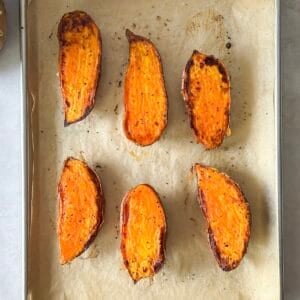 roasted sweet potato halves on a baking sheet overhead view.
