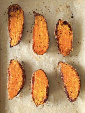 roasted sweet potato halves on a baking sheet overhead view.