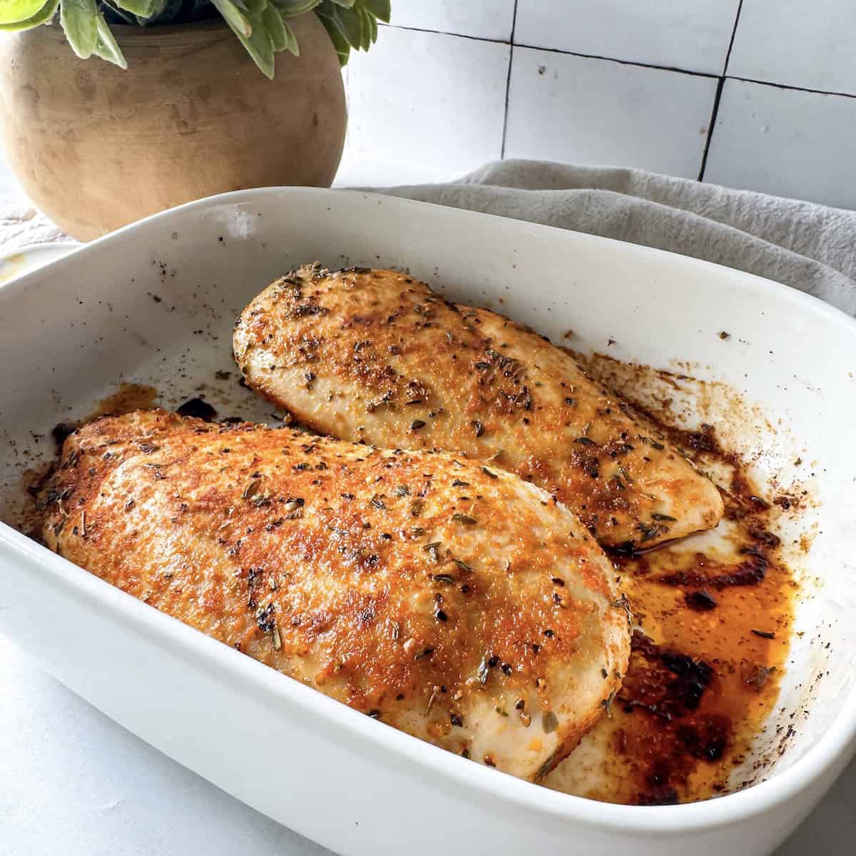 oven baked chicken breast seasoned in a baking dish.
