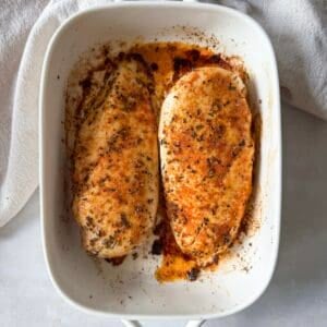oven baked chicken breast in a baking dish overhead view.