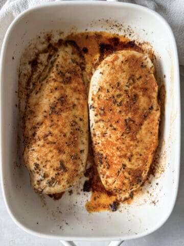 oven baked chicken breast in a baking dish overhead view.