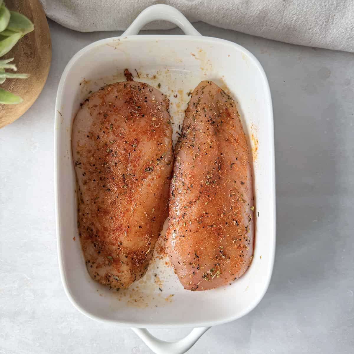 oven baked chicken breast seasoned in a baking dish.