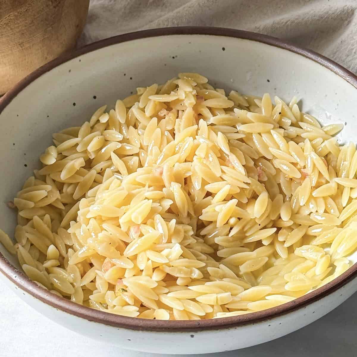cooked orzo pasta with dressing added to it.