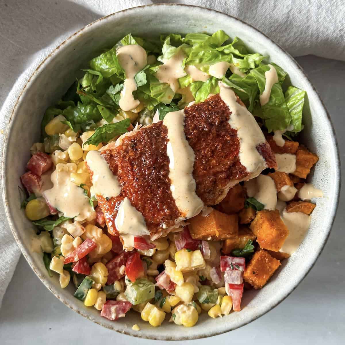 street corn salmon bowl with sweet potatoes overhead view.