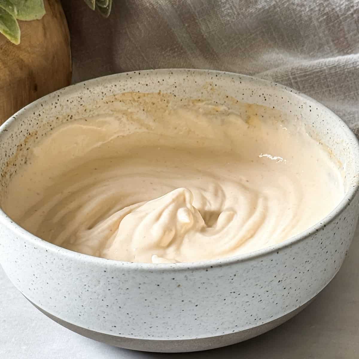 greek yogurt sriracha sauce ingredients combined in a bowl.