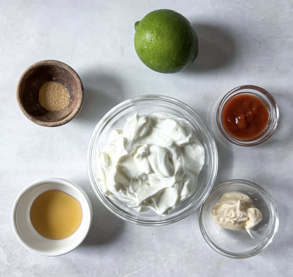 greek yogurt sriracha sauce ingredients on a table.