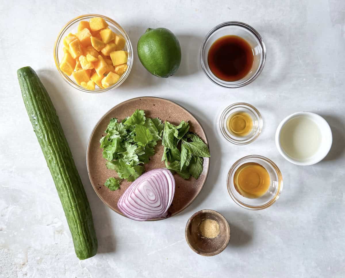 ingredients for mango cucumber salad on a table.