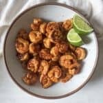 chili lime shrimp in a bowl with lime overhead.