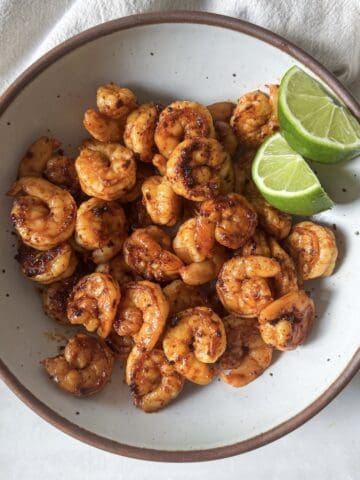 chili lime shrimp in a bowl with lime overhead.