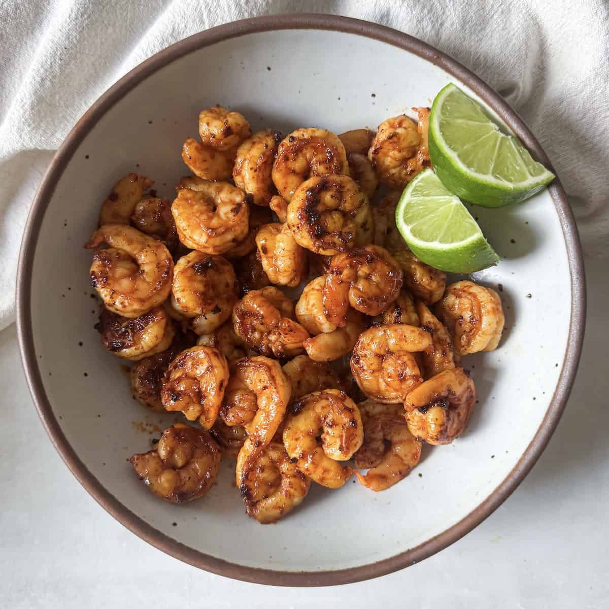 chili lime shrimp in a bowl with lime overhead.