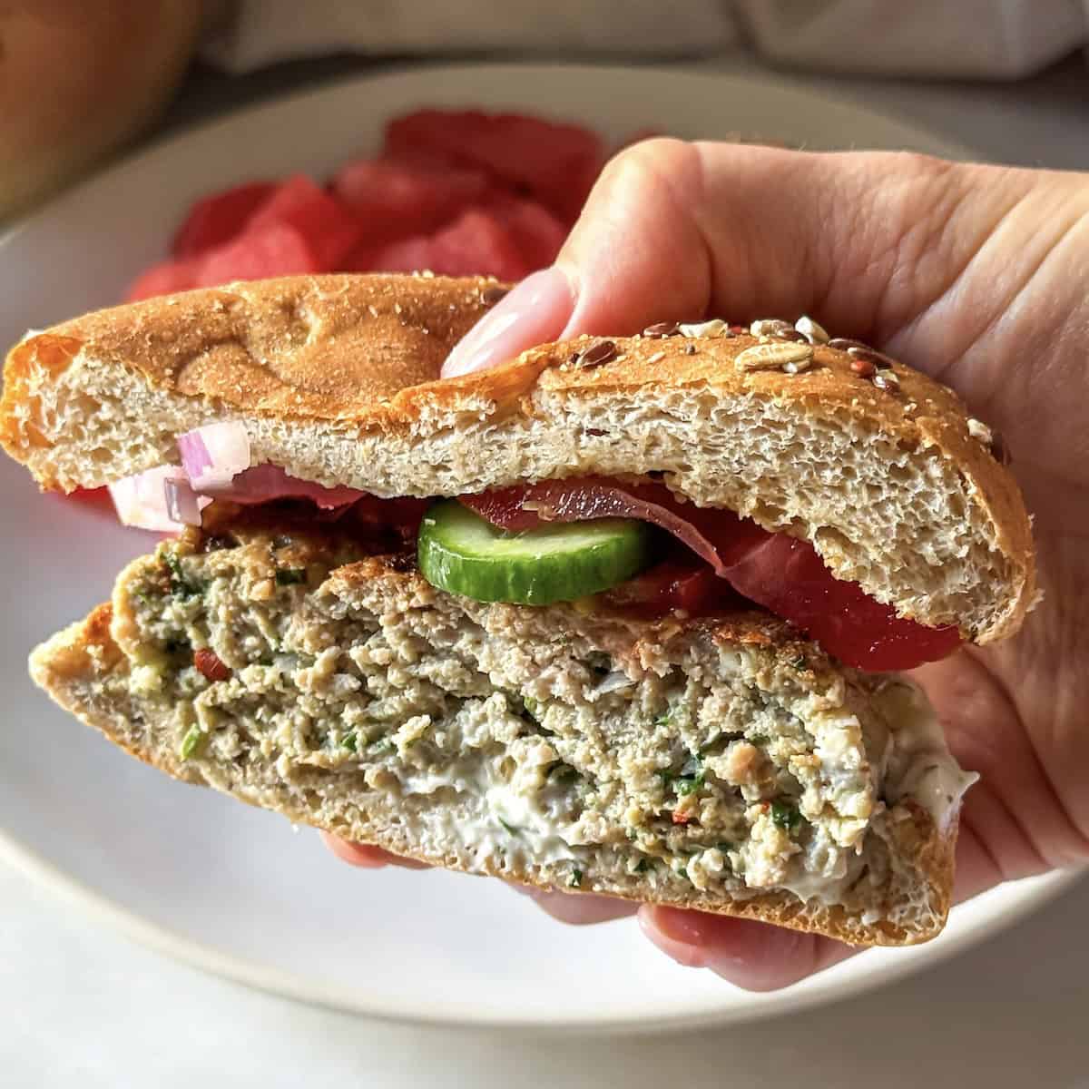 hand holding half a turkey burger feta spinach.