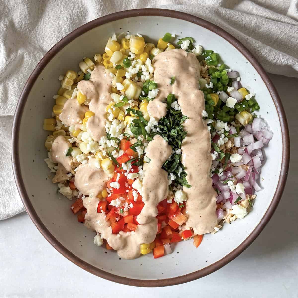 overhead view of street corn chicken salad with dressing.