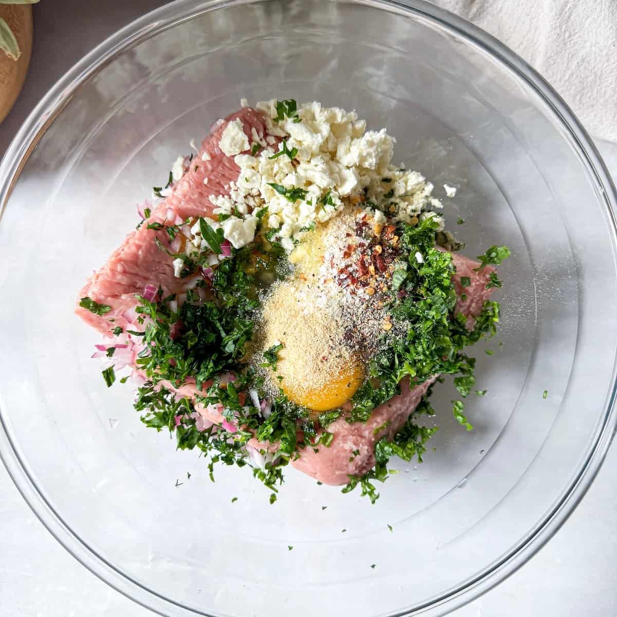 turkey burger feta spinach ingredients in a glass bowl.