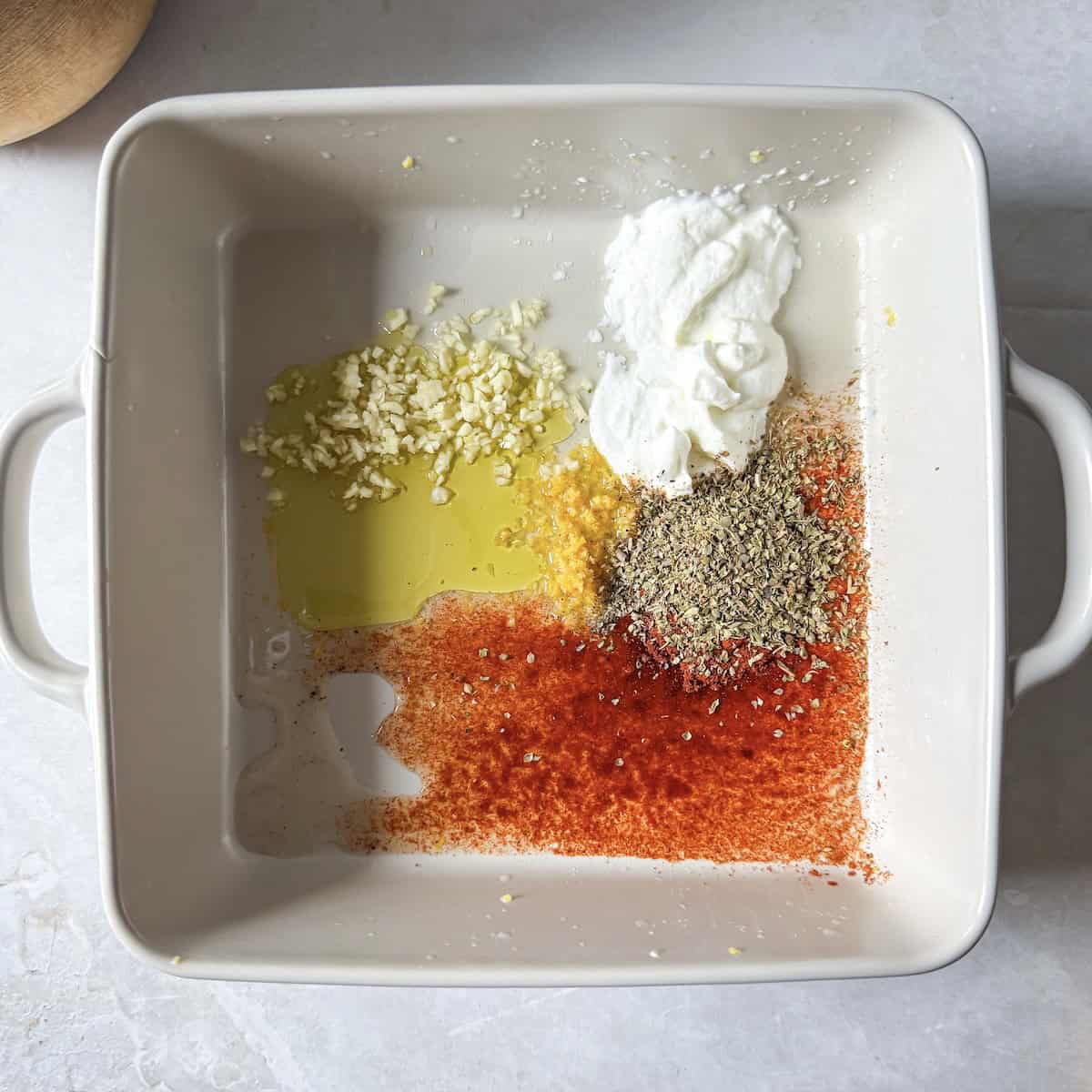 greek yogurt chicken mariande ingredients in a baking dish..