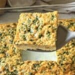 Slice of Southwest egg casserole with green peppers and cheese on a spatula.