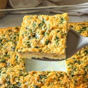 Slice of Southwest egg casserole with green peppers and cheese on a spatula.