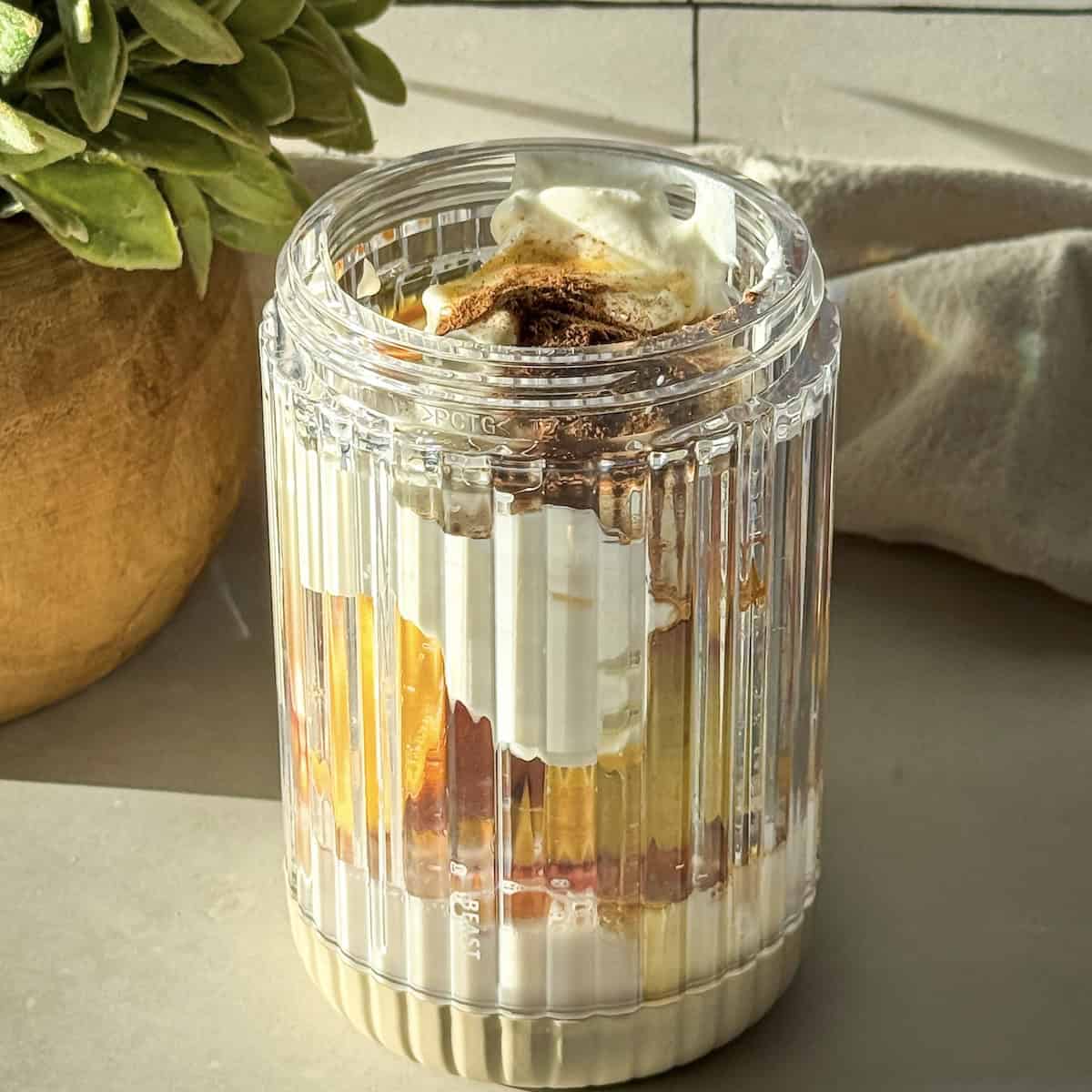 side view of peach chia pudding ingredients in a blender.