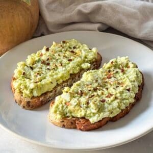 avocado toast with cottage cheese and egg on a plate.