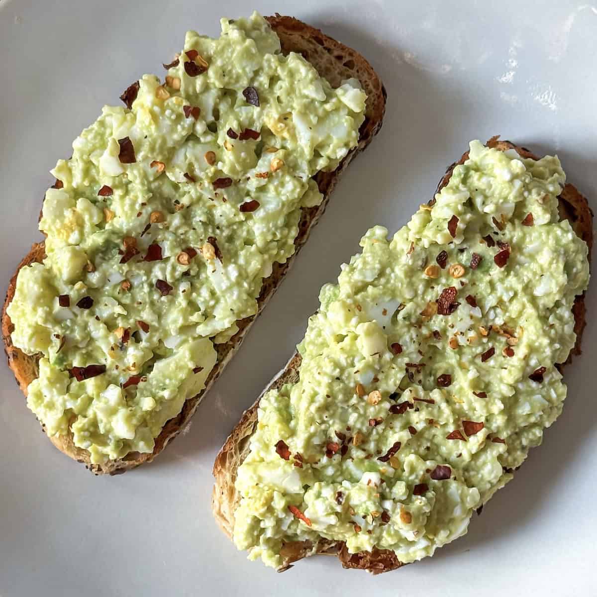 avocado toast with cottage cheese and egg on a plate close up.