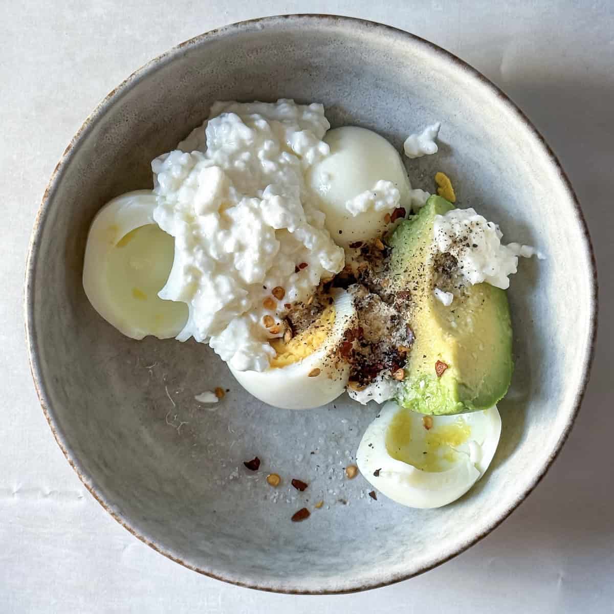 ingredients for avocado toast with cottage cheese and egg in a bowl.