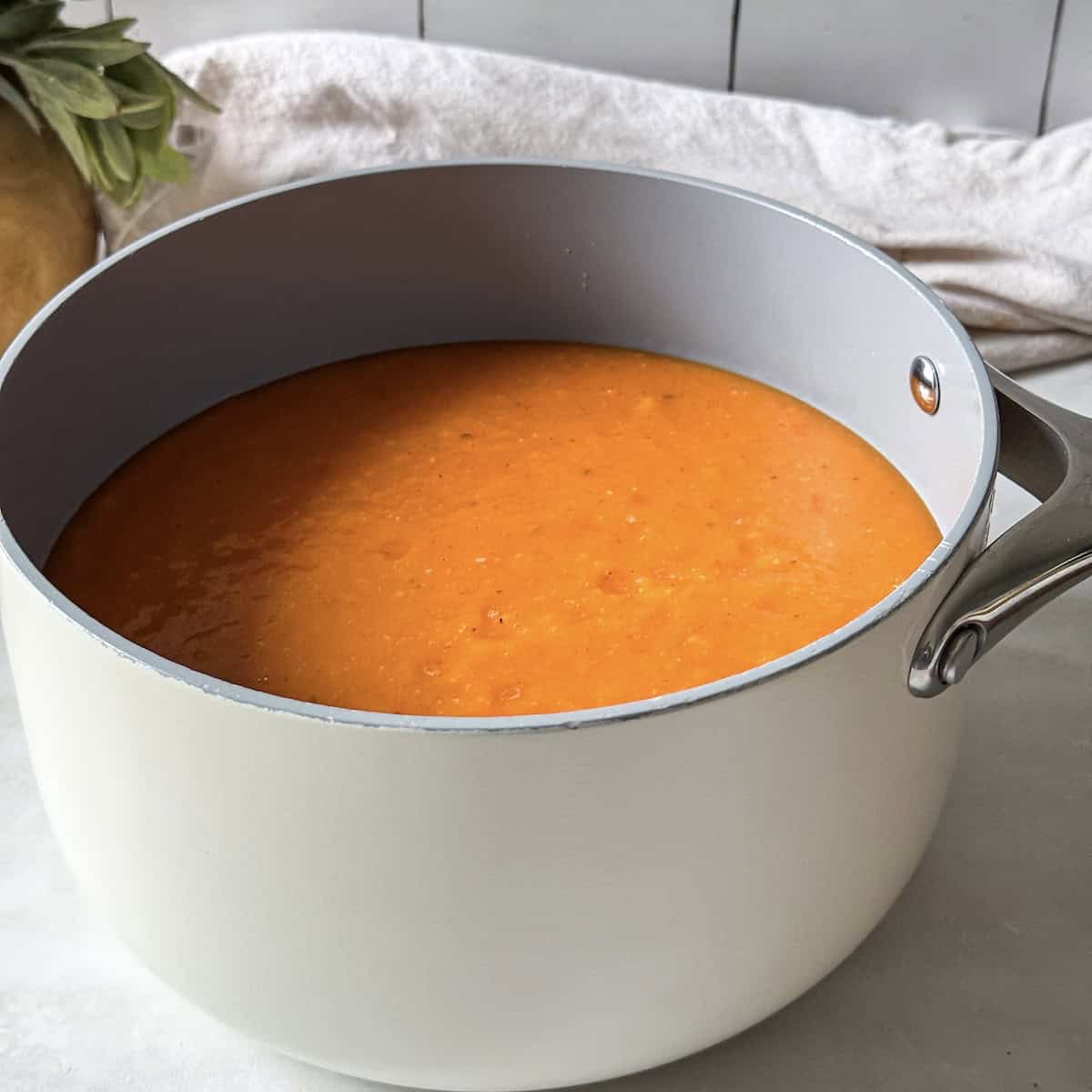 Butternut squash tomato soup in a soup pot right after being heated.