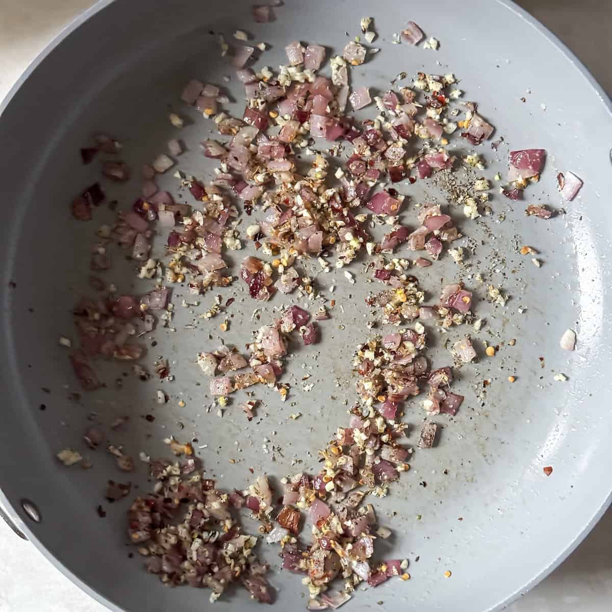 Red onion, garlic, and seasonings in a skillet.